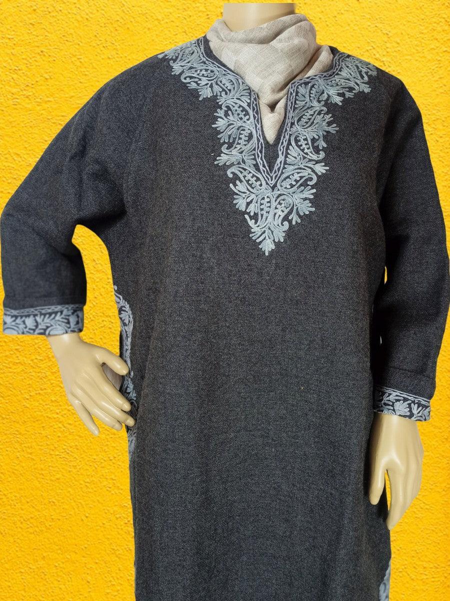 Dark grey embroidered woolen kurta with intricate light blue floral patterns on neckline, cuffs, and sides, displayed on mannequin with beige shawl against yellow textured background